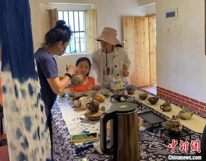 圖為：游客正在咨詢臺灣柴燒作品?！∪~秋云 攝