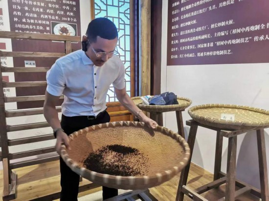 2023“一帶一路”媒體合作論壇聯(lián)合采訪團(tuán)團(tuán)員在非遺文化展示館體驗(yàn)中藥炮制技藝。（本報(bào)記者 黃超攝）