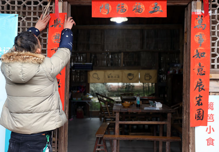 貼春聯(lián)。翠屏區(qū)融媒體中心供圖