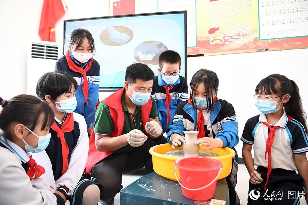 5月31日，河北省定州市定瓷藝人來到定州市清水河小學(xué)指導(dǎo)學(xué)生制作定瓷拉坯。人民網(wǎng) 周博攝