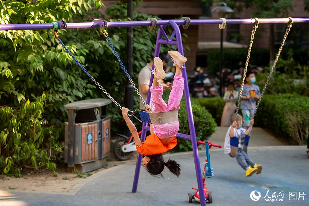 5月30日，在河北省三河市，結(jié)束一天網(wǎng)課的小朋友們正在小區(qū)的兒童樂園快樂地玩耍。自5月29日23時(shí)起，廊坊市全域?qū)嵤╈o態(tài)管理，開展連續(xù)2日的篩查性全員核酸檢測(cè)。人民網(wǎng)記者 翁奇羽攝
