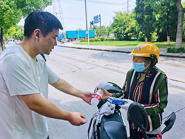 何超為過路的老人送上礦泉水和冷飲。人民網(wǎng)記者 王繼亮攝