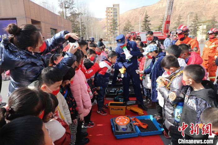 圖為小朋友們聽消防員講解消防器材?！铨埥?攝