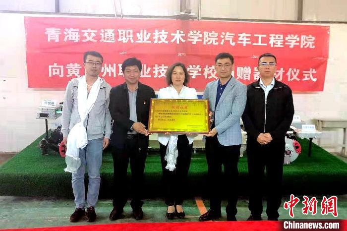 圖為李富香(中)代表學(xué)校為州縣技校捐贈器材。(資料圖) 青海省教育廳供圖