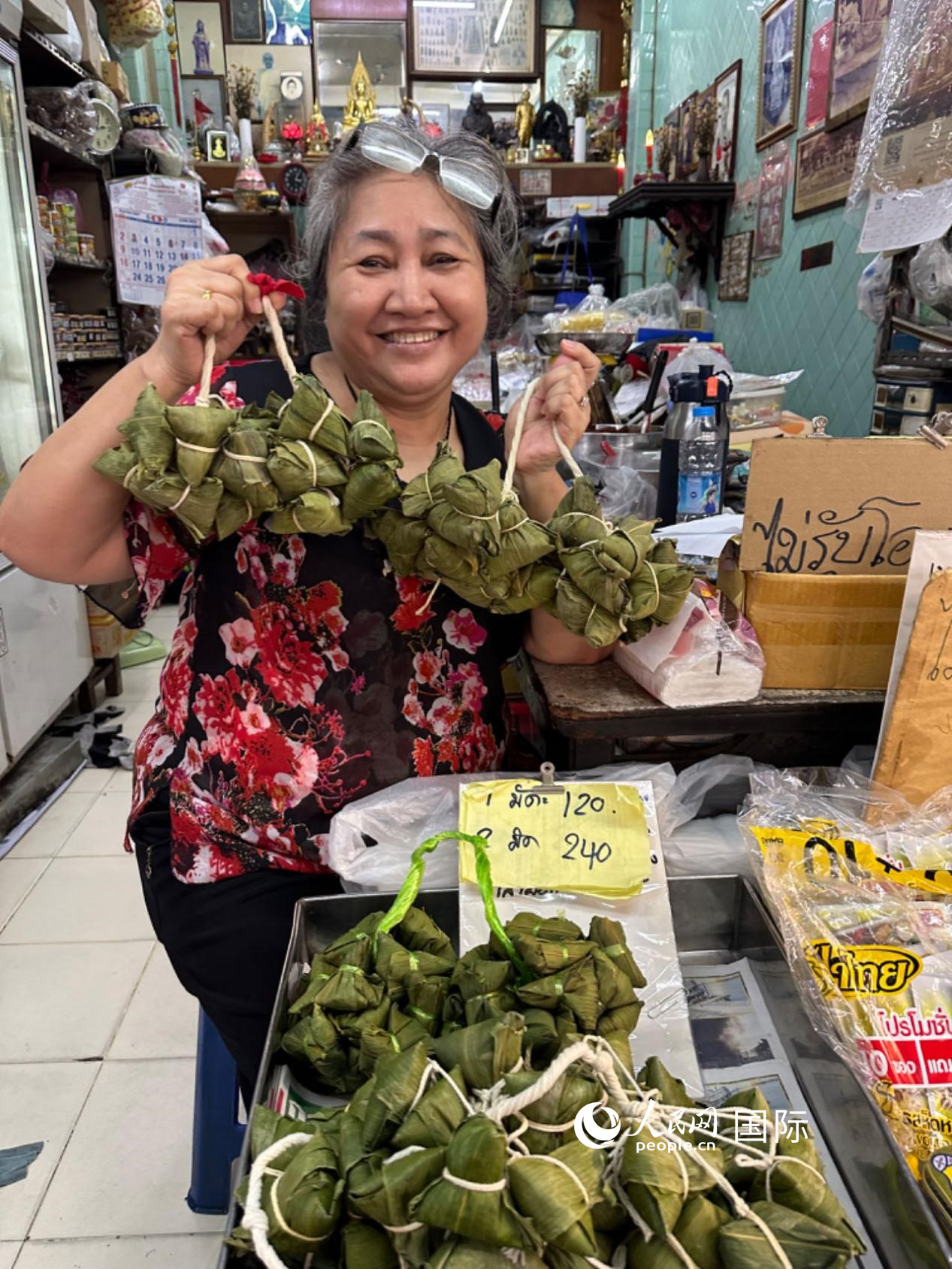 商家向顧客介紹“吉掌”（粽子的一種，一串一串，個(gè)頭較?。?。人民網(wǎng)記者 簡(jiǎn)承淵攝