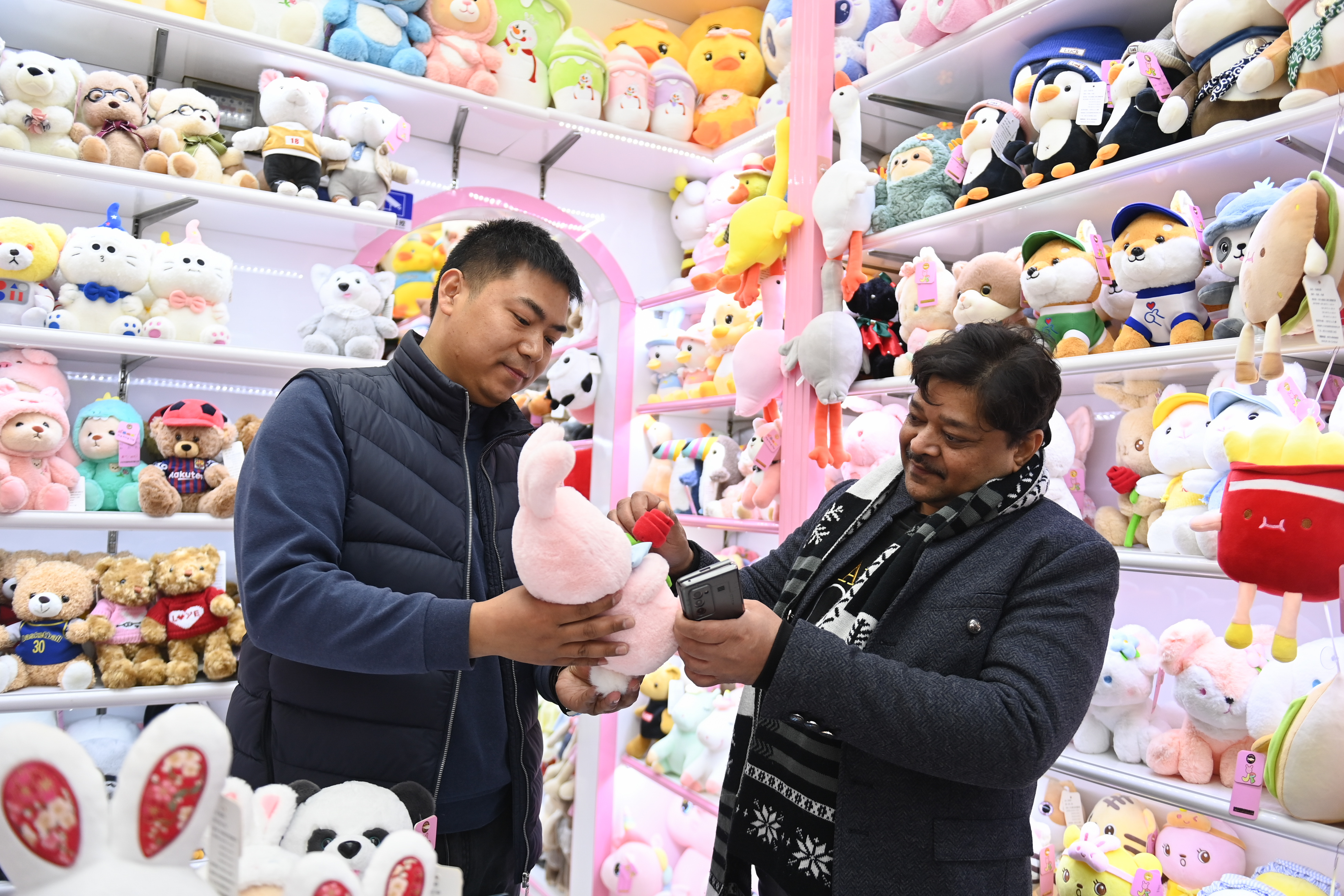2023年2月2日，來(lái)自印度的客商（右）在義烏國(guó)際商貿(mào)城的一家玩具店鋪內(nèi)選購(gòu)。