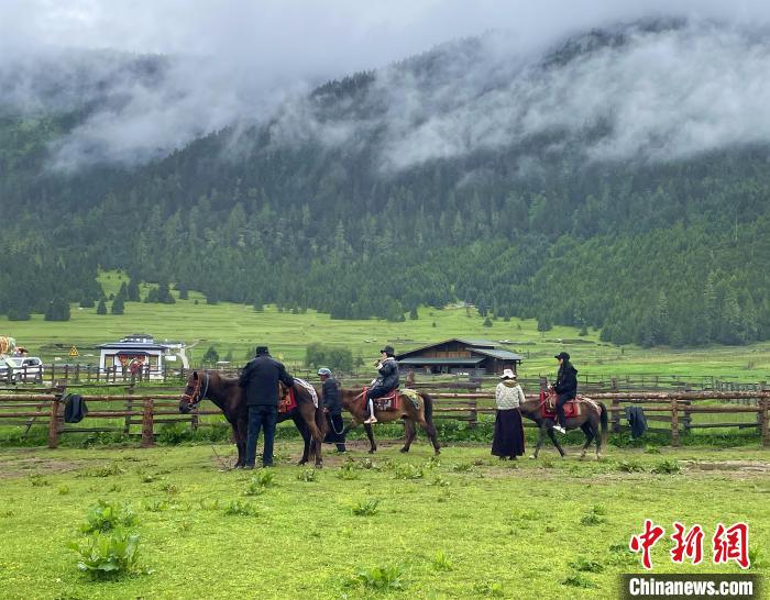 6月10日，游客在魯朗小鎮(zhèn)高山牧場景區(qū)體驗騎馬?！∪轿木?攝