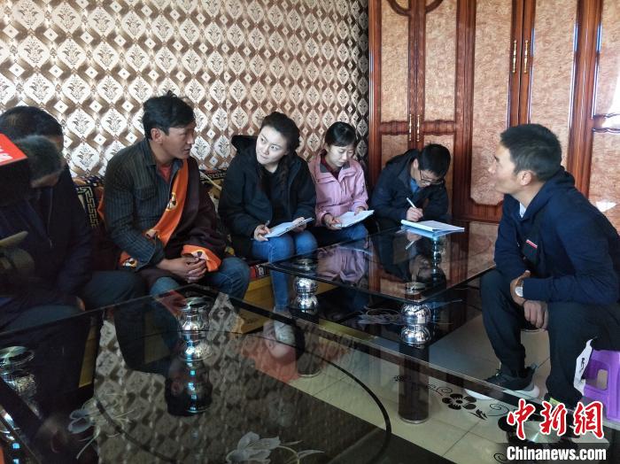 圖為調(diào)查組工作人員正在入戶調(diào)查?！∑钤鲚?攝