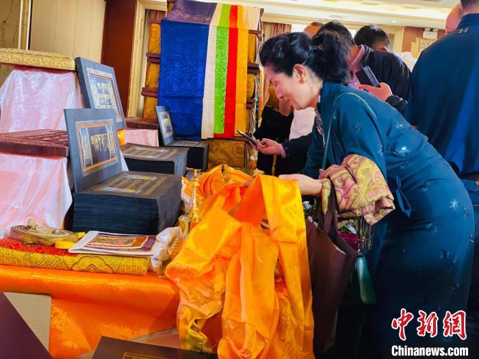 圖為現(xiàn)場藏族民眾向黃金書寫的大藏經(jīng)《甘珠爾》敬獻(xiàn)哈達(dá)?！O睿 攝