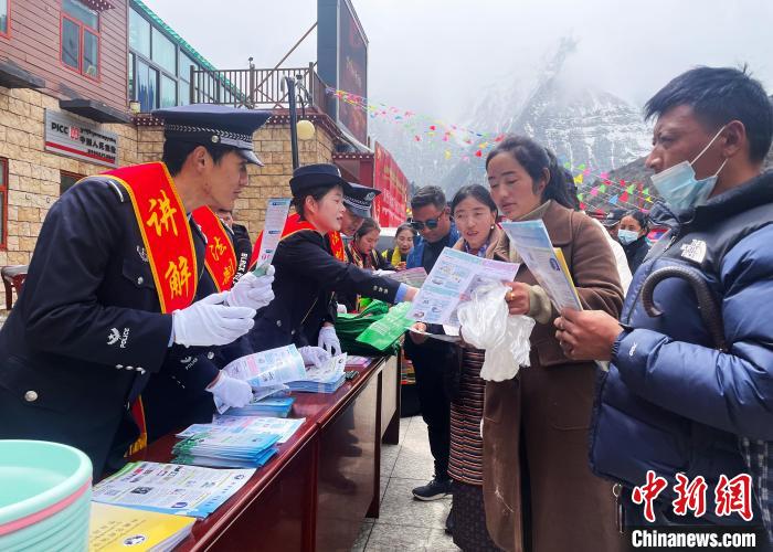 圖為山南玉麥邊境派出所民警為轄區(qū)群眾發(fā)放法律知識(shí)宣傳單?！＄婗?　攝